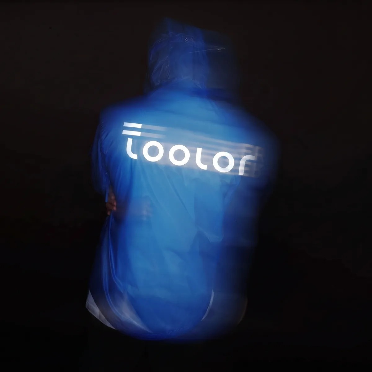 The Toolor wordmark flaring bright under a headlight on the back of a blue shell in the dark
